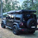 Jeep Wrangler carrying an On The Horizon rooftop tent and 270 degree awning at camp
