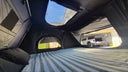 Inside the On The Horizon 1.9 Penthouse rooftop tent, the full 190cm wide bed with the roof window open above it