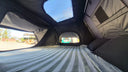 Inside the 1.9 Penthouse looking out the rear arch window, with the insulated side wall and the roof window above the bed