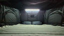 The interior LED strip lit inside the 1.9 Penthouse, showing the full width of the bed and the windows on both sides